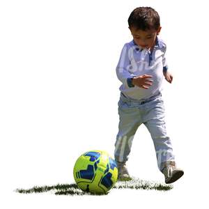 backlit boy playing football in the park