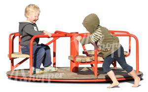 two boys playing on a carousel