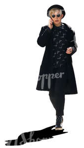 stylish woman in black walking and talking on the phone