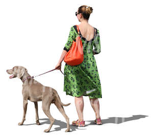 woman in a green dress walking a dog