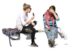 two young women sitting and eating ice cream