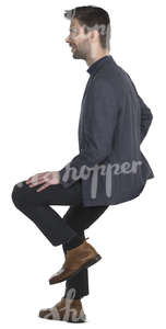 man in a suit sitting on a bar stool