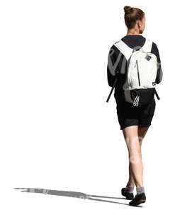 woman with a white backpack walking in the sunlight