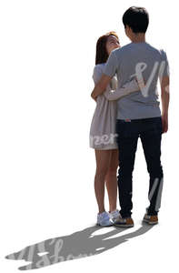 backlit young asian couple standing and looking at each other