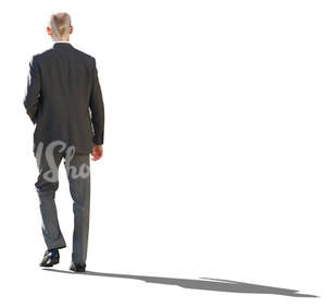 backlit businessman in a grey suit walking