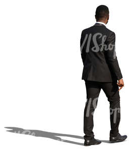 african man in a black formal suit walking
