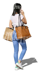 woman with shopping bags walking and talking on the phone