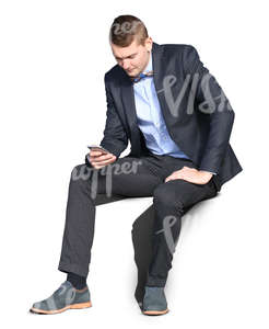 young man wearing a suit sitting and browsing his phone