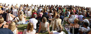 big group of people sitting on a grass on an outdoor event