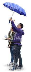 two asian people standing under an umbrella and looking up