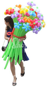 woman in a blue dress walking and carrying balloon flowers