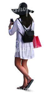 woman with a large hat and white dress doing some shopping