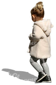 small girl with a beige cardigan walking on the street