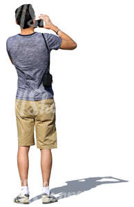 man in shorts standing and taking a picture