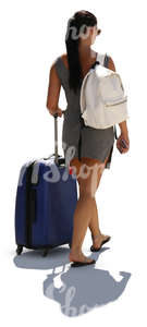 backlit woman in a summer dress walking with a big suitcase