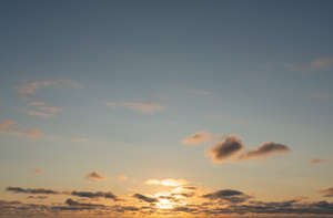 sunset with sun behind some small clouds