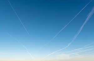 deep blue clear evening sky with contrails