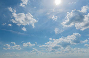 daytime sky with sun and white clouds
