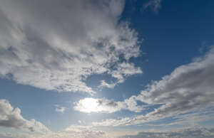 daytime sky with sun behind a small cloud
