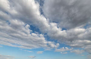 pale blue daytime sky with large white clouds