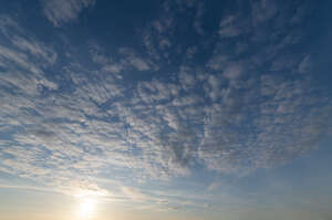 sky with sun and small scattered clouds