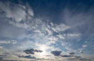 afternoon sky with sun low behind the clouds