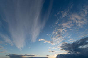 sun setting behind small clouds