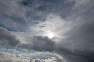 very cloudy sky with sun visible between clouds