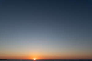 bright cloudless sunset with sun on the horizon