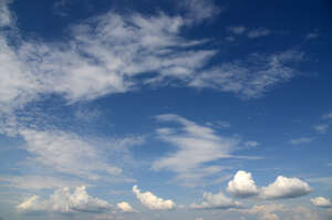 dark blue daytime sky with small white clouds