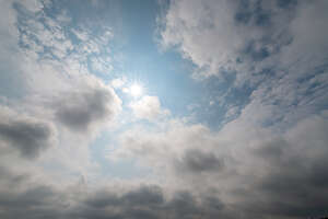 daytime hazy sky with sun and clouds