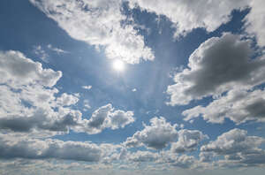 daytime sky with sun and clouds