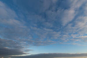 deep blue sky with grey clouds