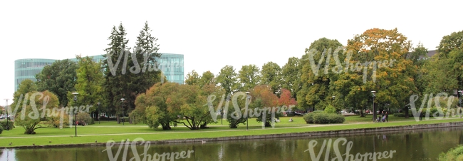 park with a pond and a building in the back