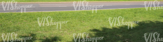 grass field with asphalt road