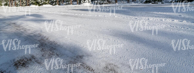 snow covered road with tree shadows