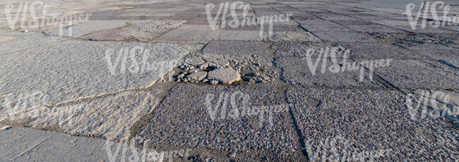 worn out tarmac plates in sunlight