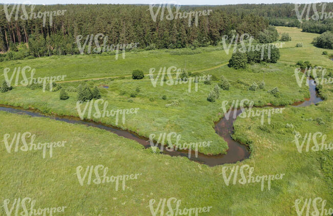 aerial view of a river flowing between meadows