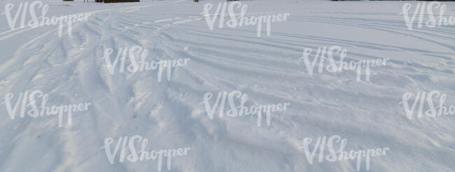 field of snow with tyre tracks