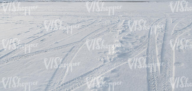 even field of snow with tyre tracks