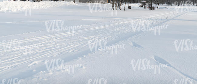 snow covered field with ski tracks