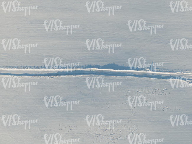 aerial view of a road through snowy fields