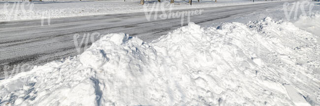 road in winter lined with heaps of snow