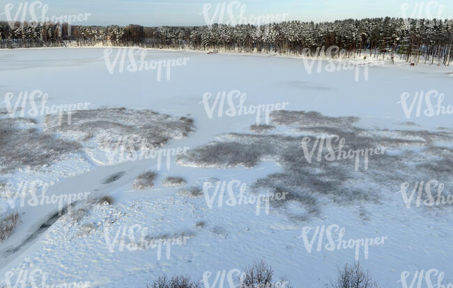 aerial view of a frozen forest lake