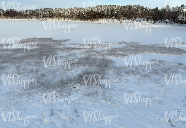 aerial view of a frozen forest lake