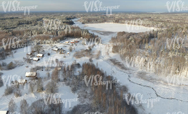 aerial view of countryside with houses and lake in winter