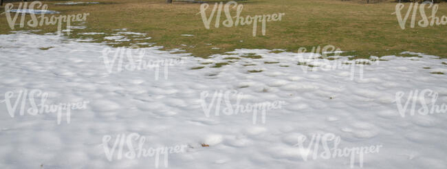 lawn in early spring with patch of snow