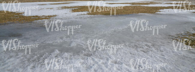 field of grass with snow and ice patches