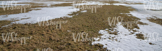 field of grass with snow patches