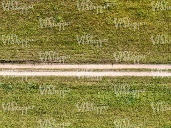 top view of a road between grass fields